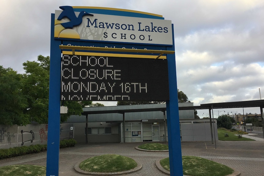 A sign outside a school with an electronic message saying it is closed