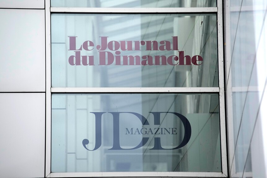 A poster in a window advertising a French newspaper