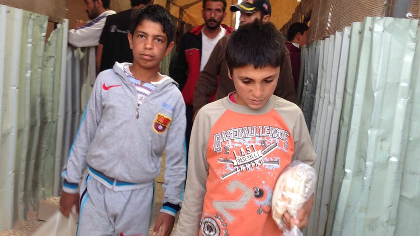 Young boys carrying loaves of bread back to their families at Zaatari camp in Jordan.
