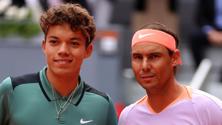 Tennis players Darwin Blanch and Rafael Nadal pose for a photo together at the net before their match at the Madrid Open.