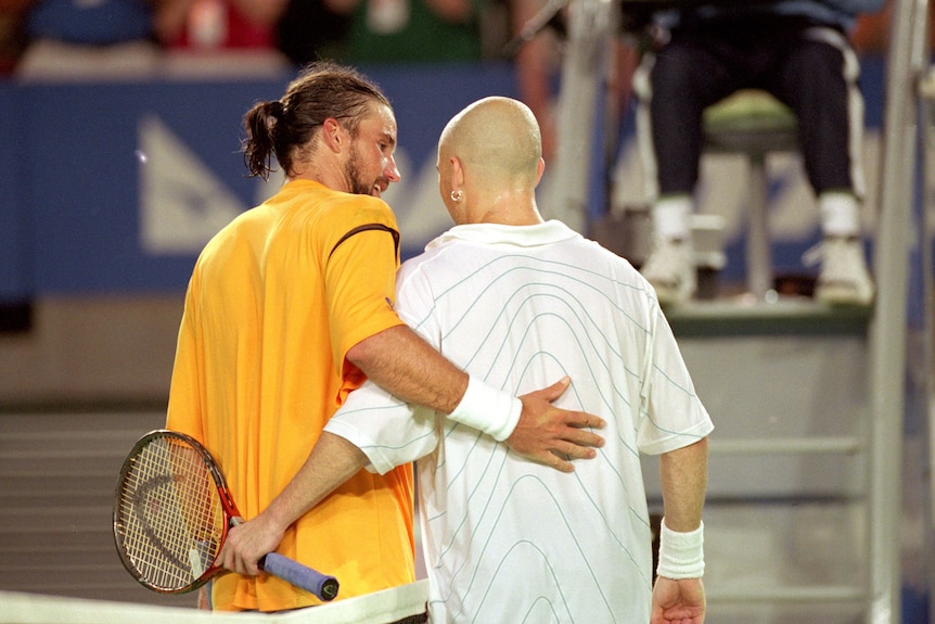 Pat Rafter hugs Andre Agassi as seen from behind
