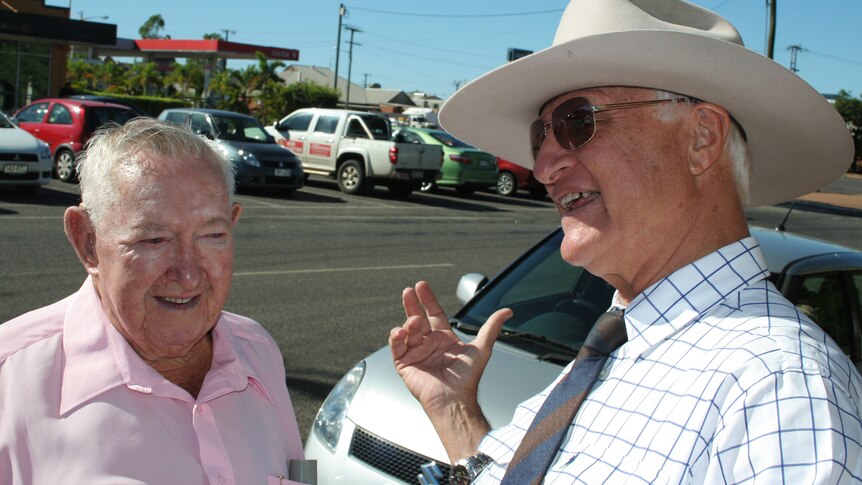 Bob Katter speaks to a member of the public after handing out how to vote cards at Mount Isa Central High School today.