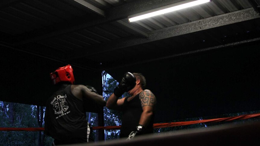 A photo of boxers training beneath fluorescent lights in the Bush Church.