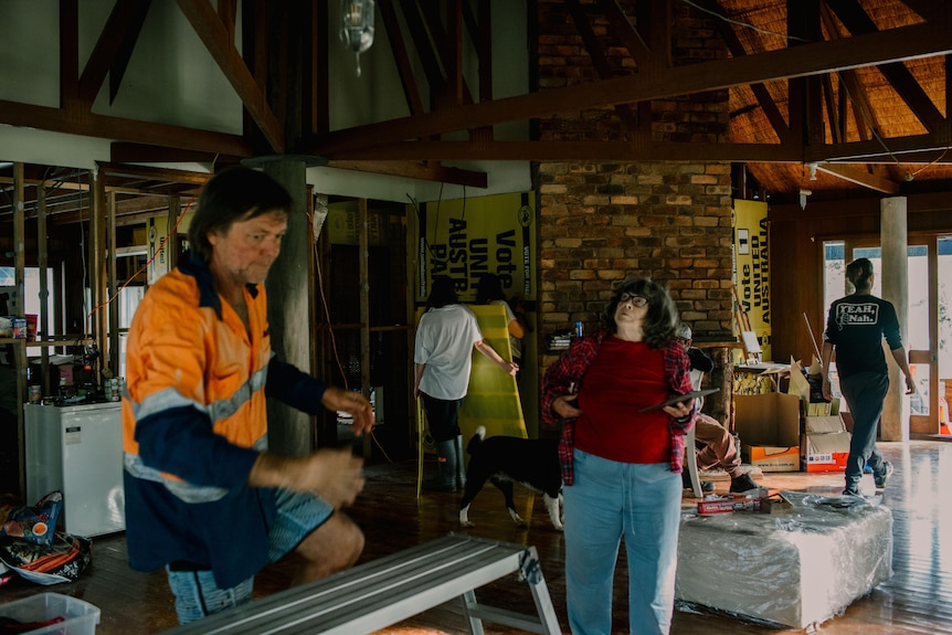 A man and a woman in a house with building works going on around them.