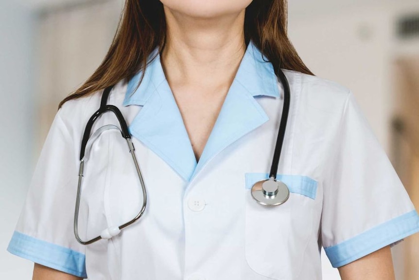 A female in a doctor's uniform stands with a stethoscope around her neck.