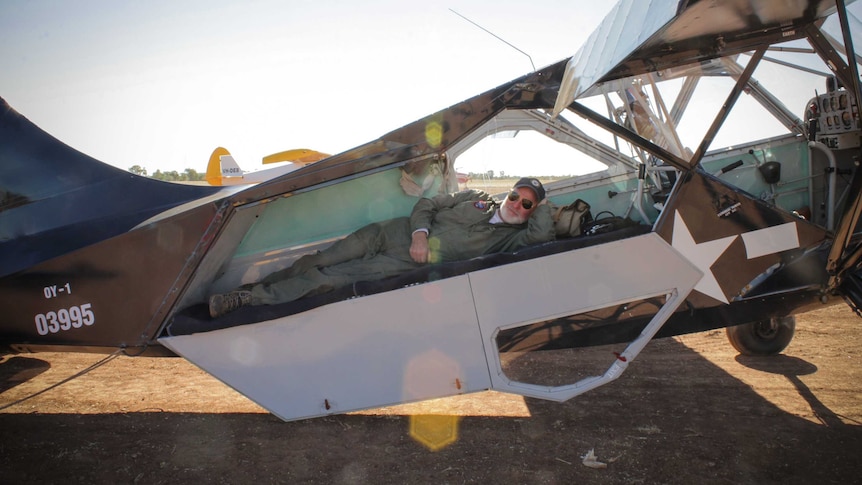 Bruce Pearcey lying in the back of a 1943 Stinson aircraft.