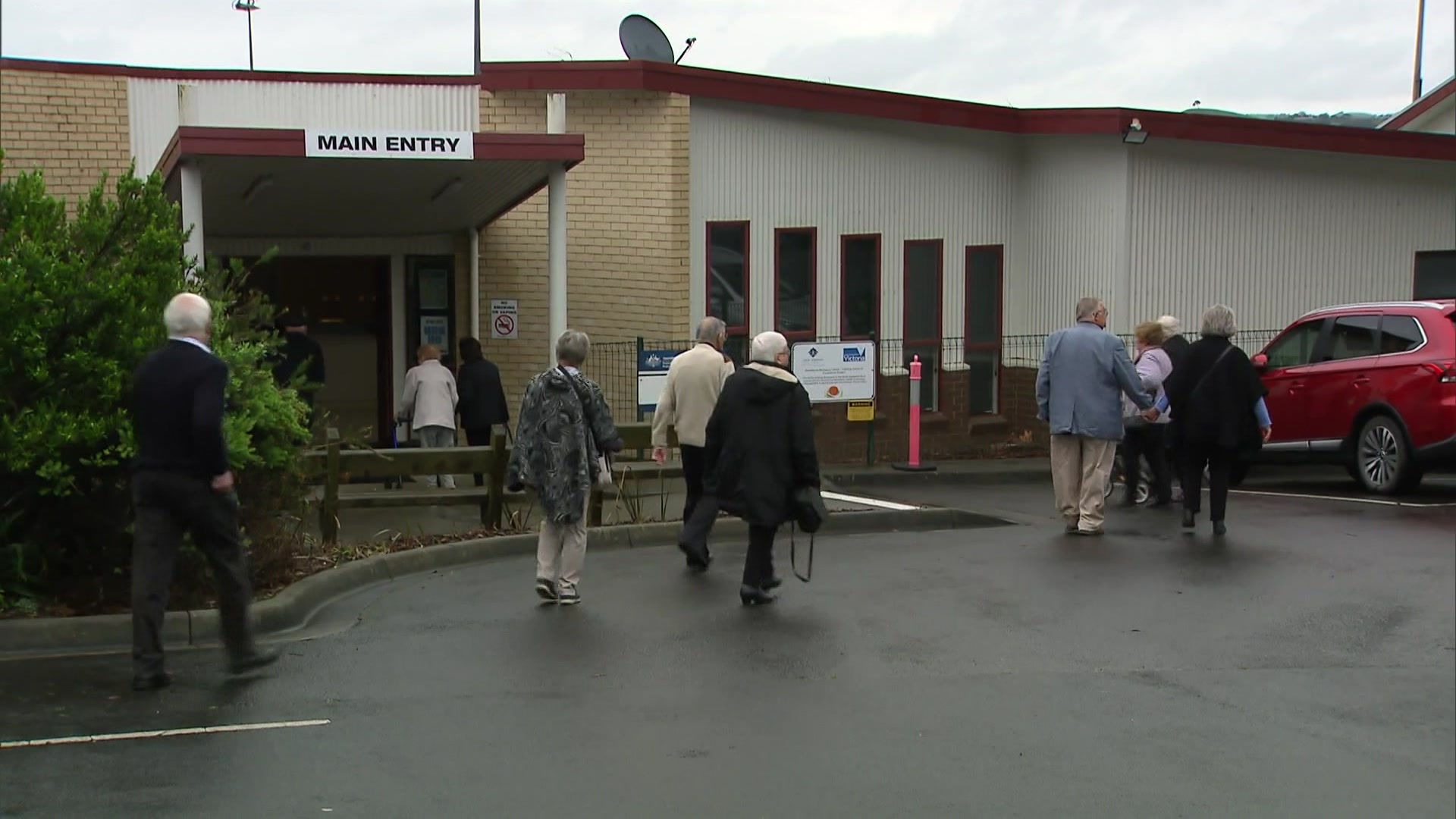 A small crowd of people walking into a hall for the public memorial of one of the victims of the suspected mushroom poisoning.