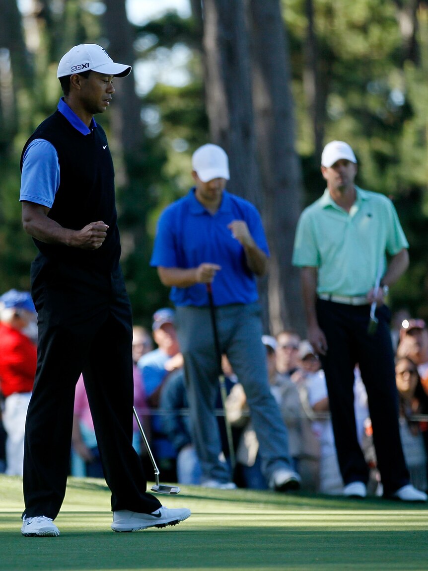 Solid start ... Tiger Woods (paired with Tony Romo, C) sinks one at the 17th.