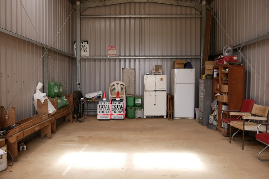 an old shed filled with equipment and outdated furniture.