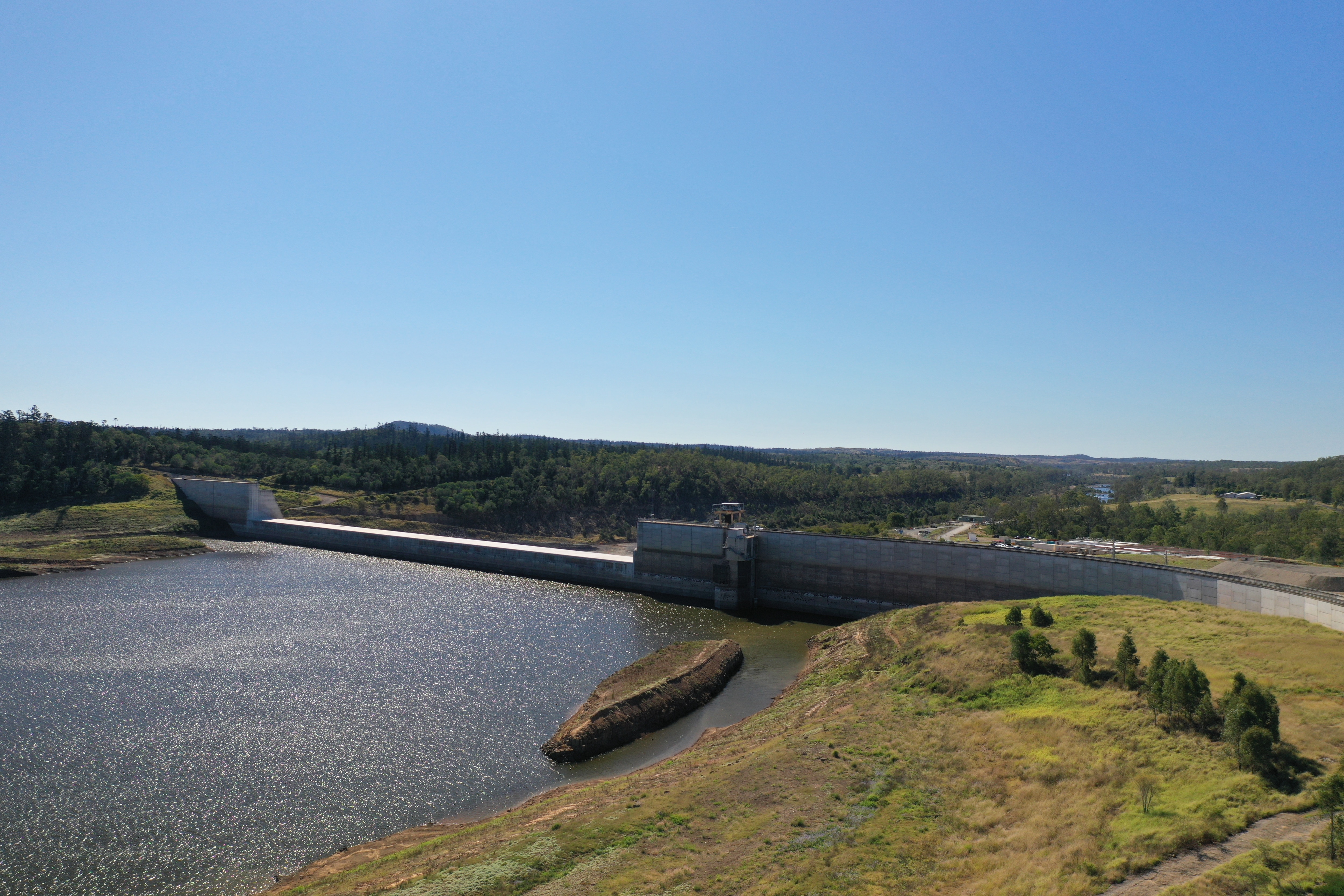 Water sitting in a dam with green grass around it.