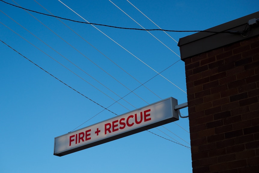 A fire and rescue sign against the blue sky.