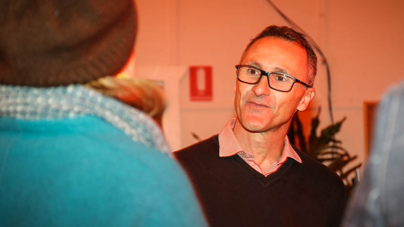 Richard Di Natale close-up chatting to party members