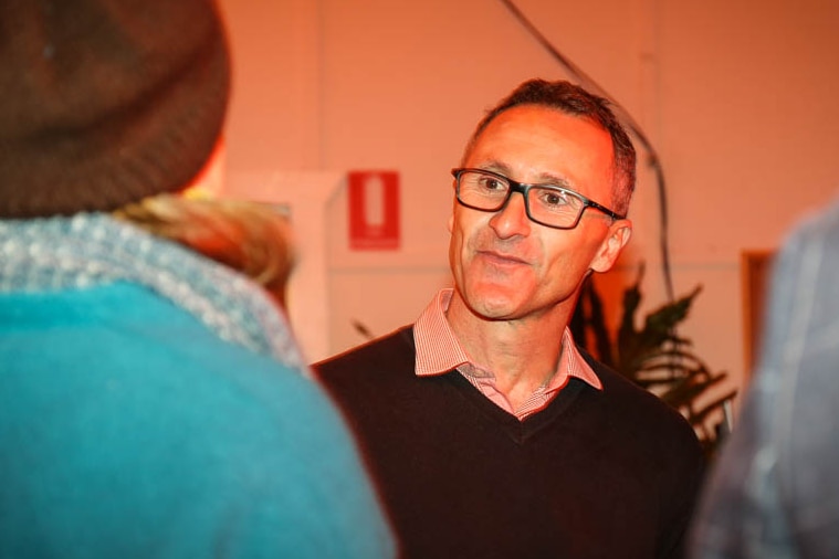 Richard Di Natale close-up chatting to party members