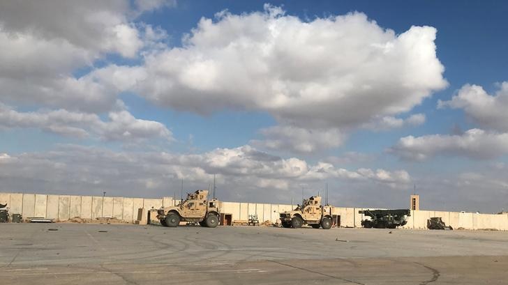 Military vehicles pictured at a distance at the Ain al-Asad air base in Iraq.