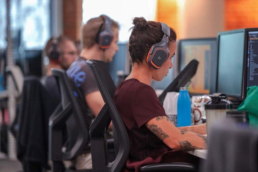 A few video game designers work at their desks at Gameloft, a video game development studio in Brisbane