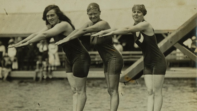 Three female swimmers on a diving board in 1912