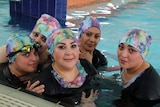 Five women wearing headgear in a  swimming pool