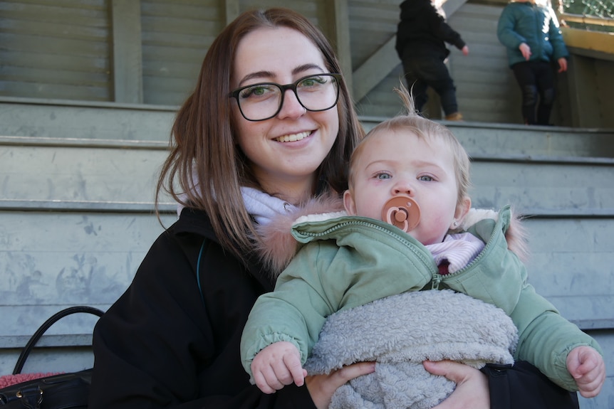 A young woman with her child sitting on her lap. 