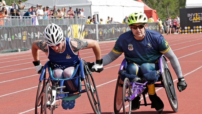 American Stephen Simmons helped by Mark Urquart at the Invictus Games.
