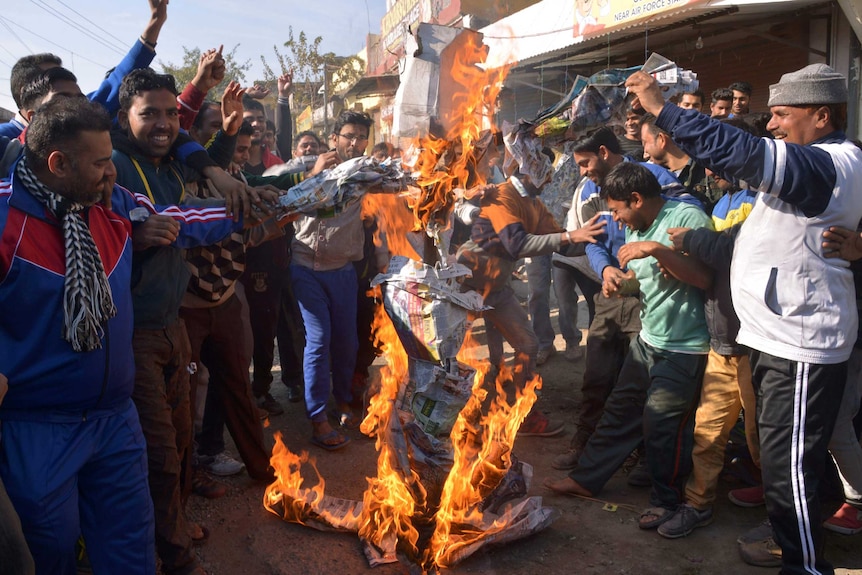 People burn items on a street.