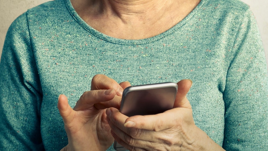 A woman in a green shirt using a mobile phone