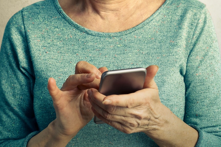 A woman in a green shirt using a mobile phone