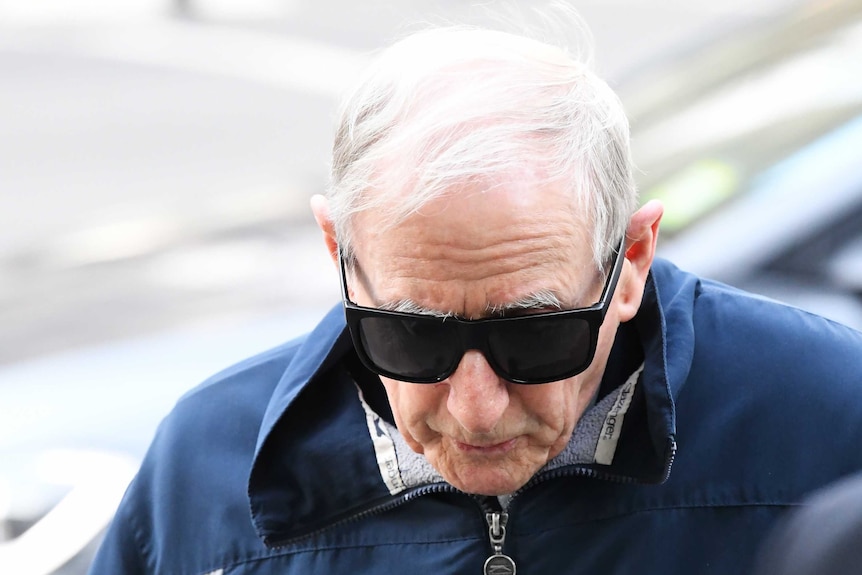 Marist Brother Gerard McNamara enters the Victorian County Court wearing dark sunglasses.