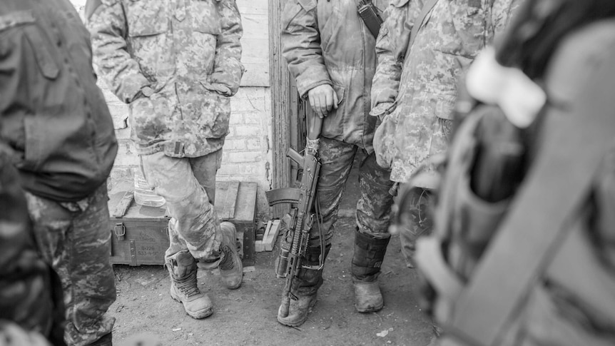 Ukrainian soldiers stand in a circle.