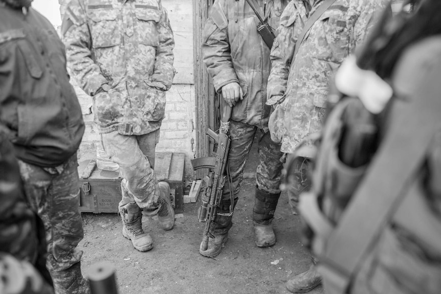 Ukrainian soldiers stand in a circle.