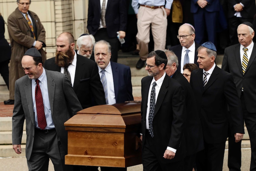 A casket is carried out of Rodef Shalom Congregation after the funeral services for brothers Cecil and David Rosenthal.