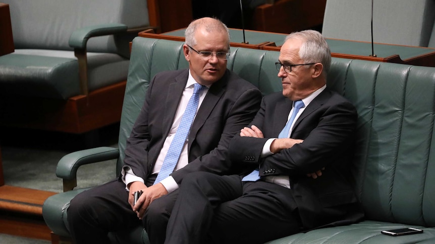 Malcolm Turnbull sits with his harms crossed listening to Scott Morrison in the House of Representatives