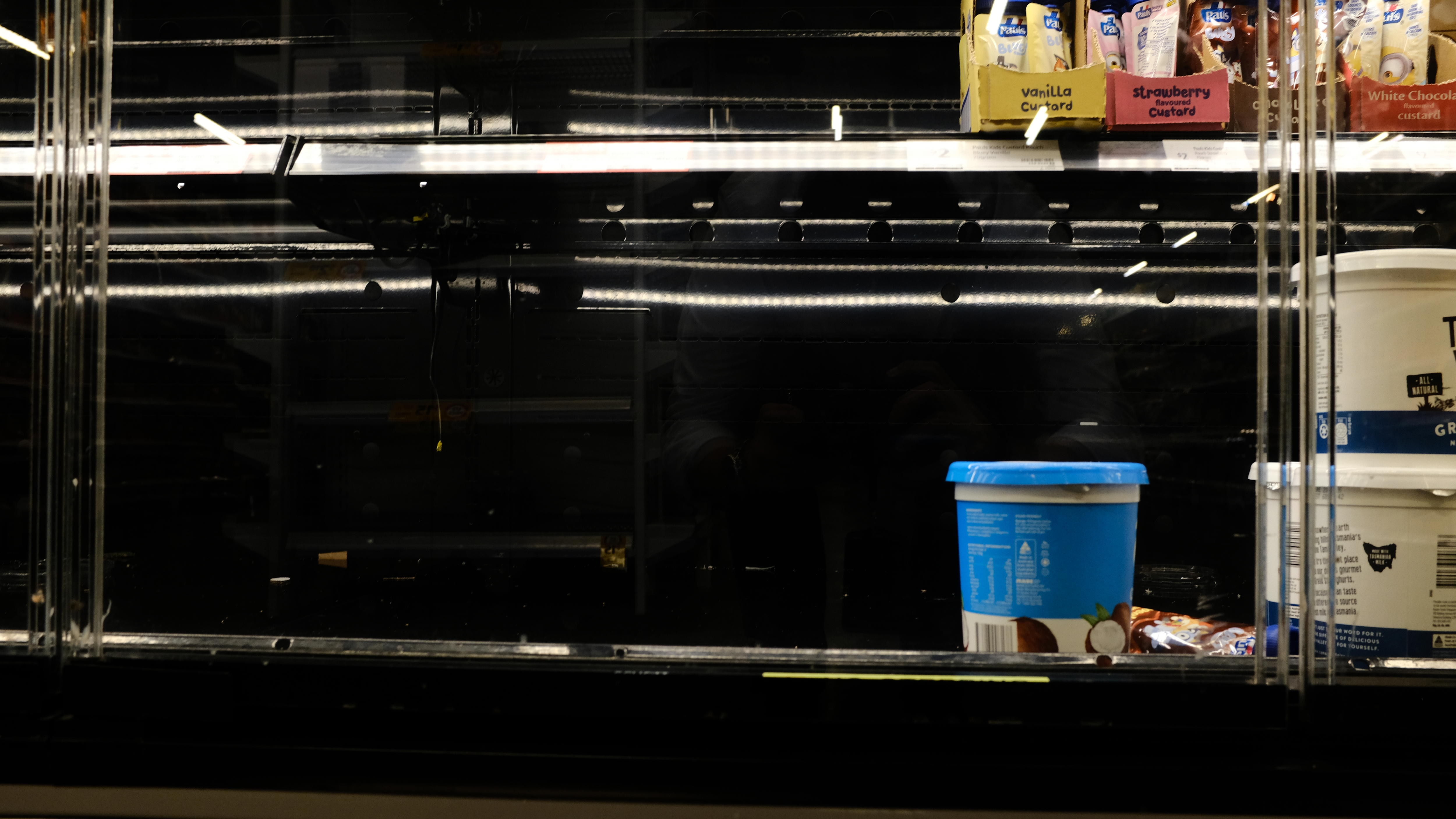 An empty shelf in a supermarket dairy fridge.