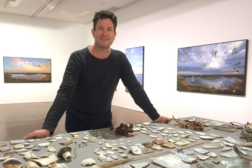 Artist Hobie Porter with broken crockery, glass, twigs and seed pods he's collected at Tower Hill