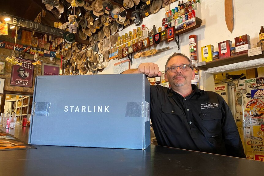 Pub worker poses with 'Starlink' box in a pub