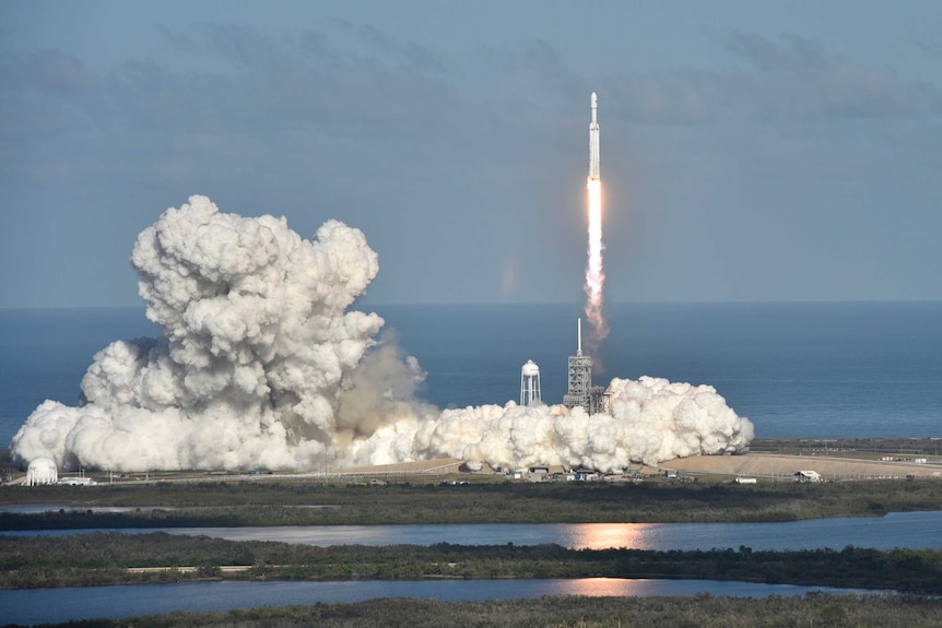 A rocket takes off, creating a large cloud of smoke.