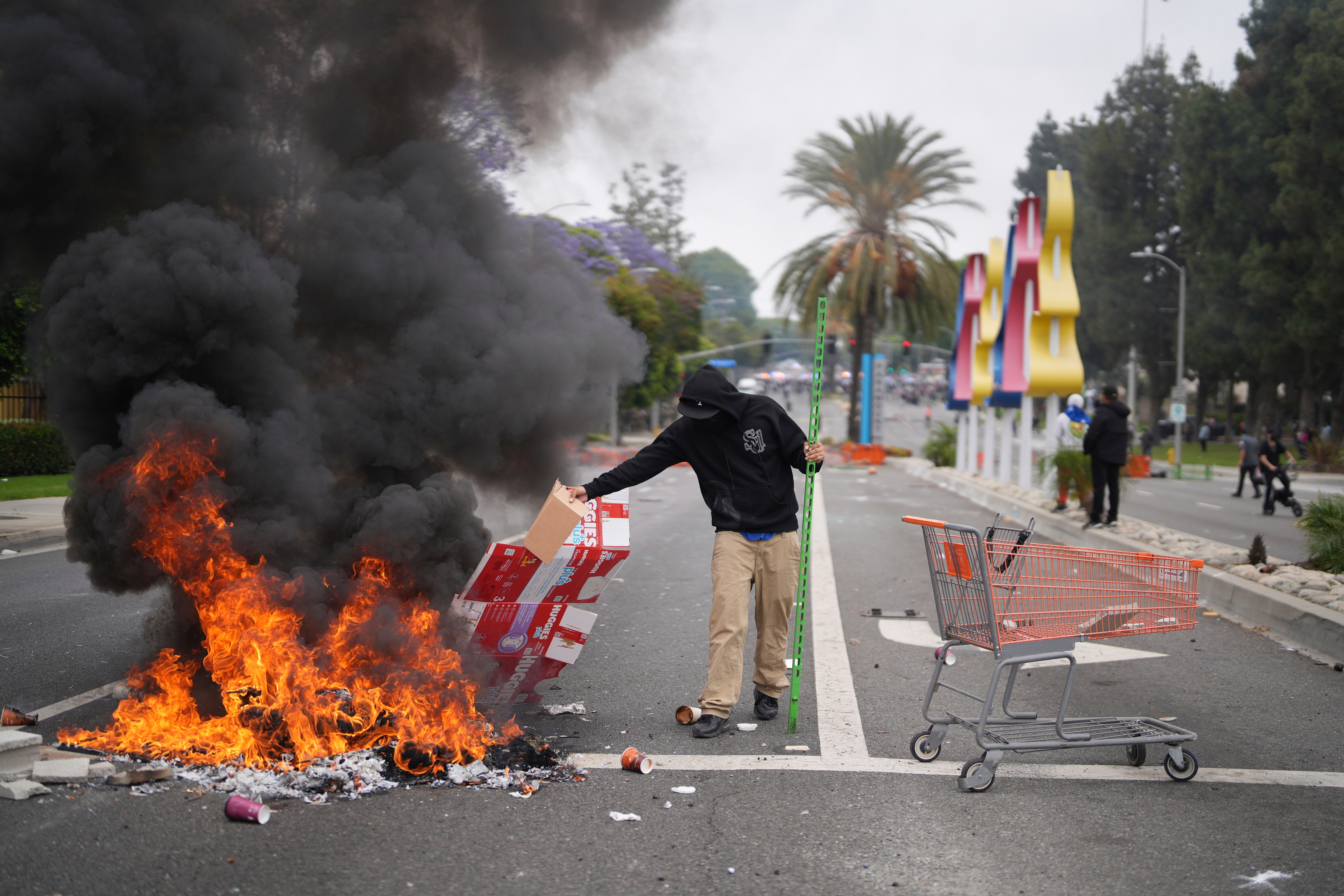A person placing debris in a fire on a road