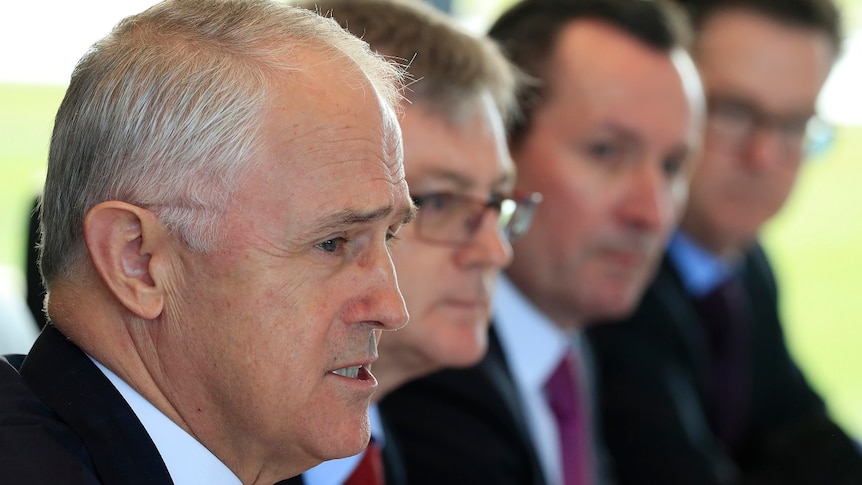 Close up of Malcolm Turnbull who is seated next to three other men.