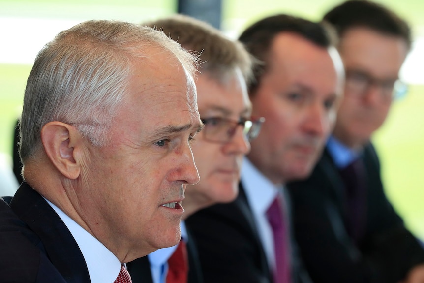 Close up of Malcolm Turnbull who is seated next to three other men.