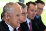Close up of Malcolm Turnbull who is seated next to three other men.