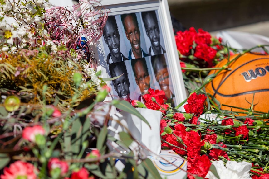 Flowers are laid next to framed photos of Liep Gony and a basketball.