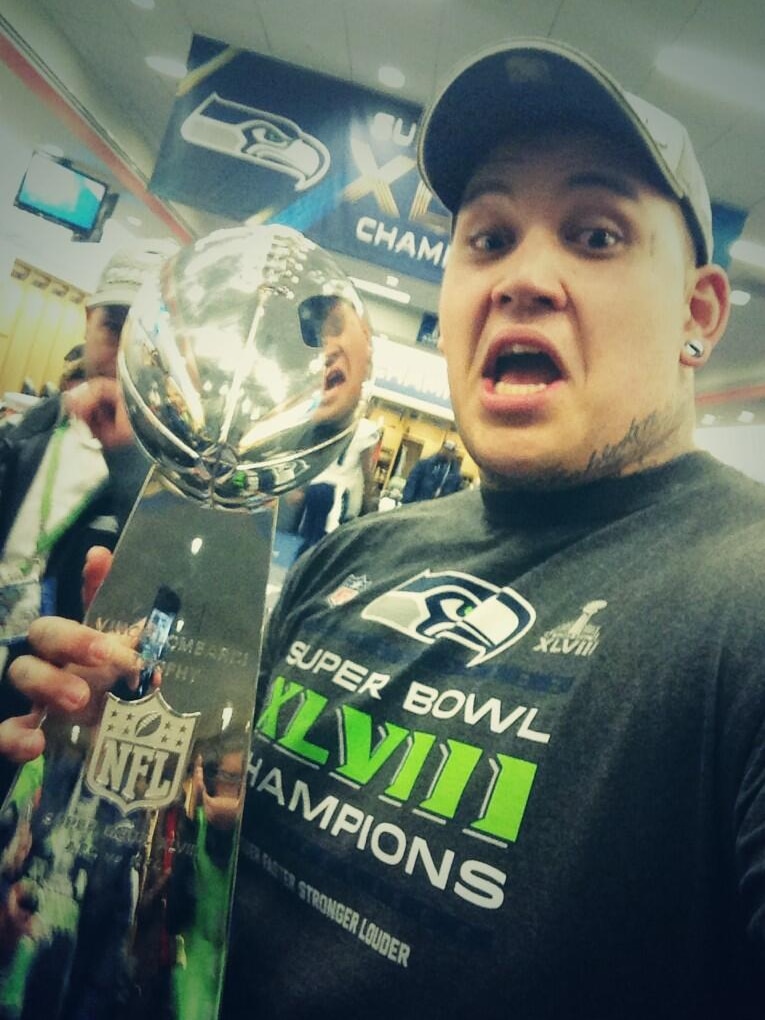 Australia's Jesse Williams poses with the Vince Lombardi Trophy awarded to the Super Bowl winners.