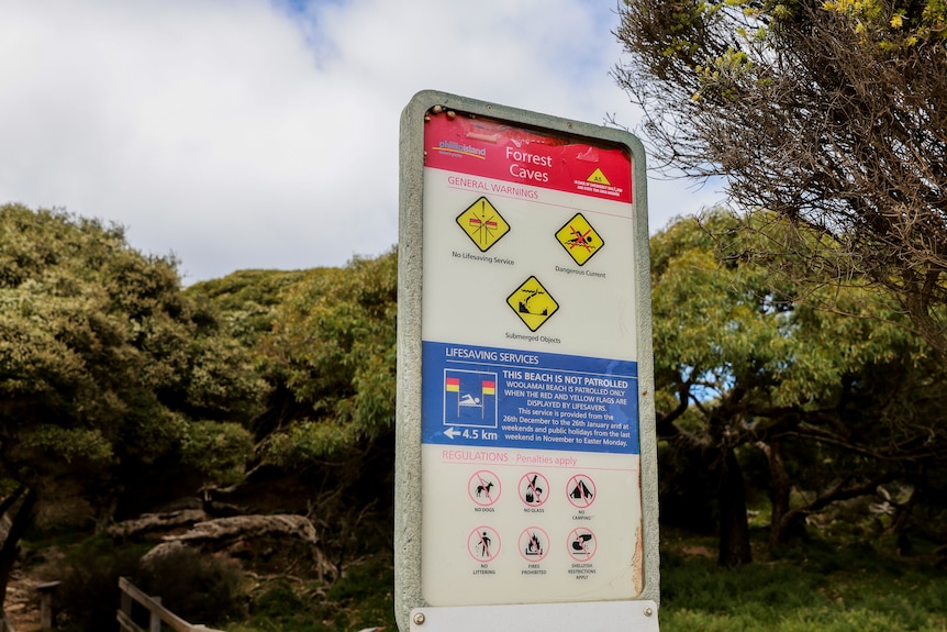 Warning sign indicating strong current at a beach.