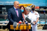 Peter Dutton addresses the media from a naval vessel. 