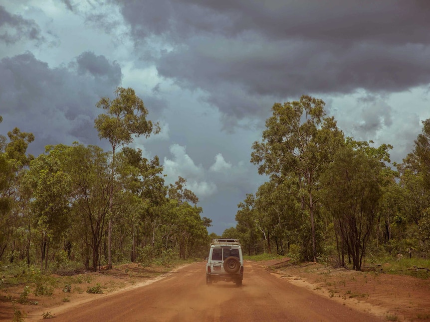 Troop carrier flicks up red dust on the way to Coopers Creek in remote Arnhem Land, Northern Territory.