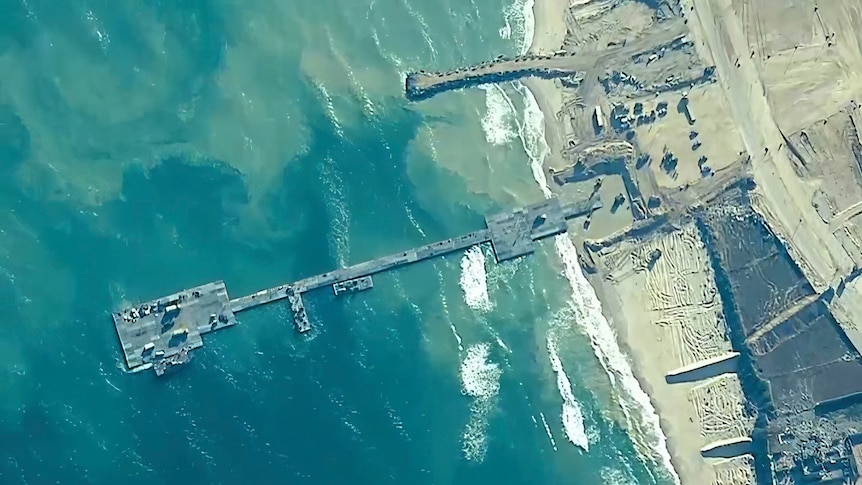 A bird eye view of a pier connected to a beach. 