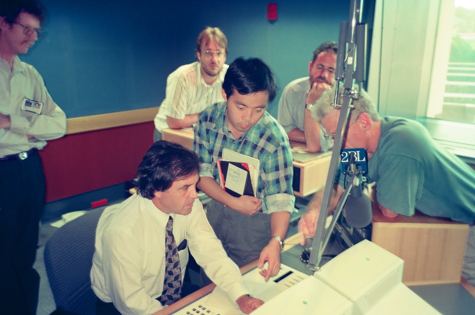 a man points to a studio control desk