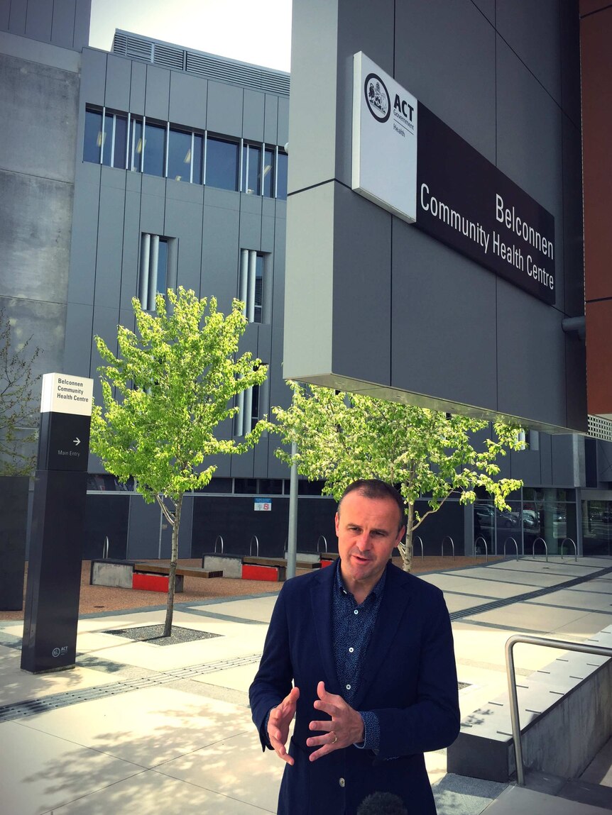 Andrew Barr underneath a health centre sign.