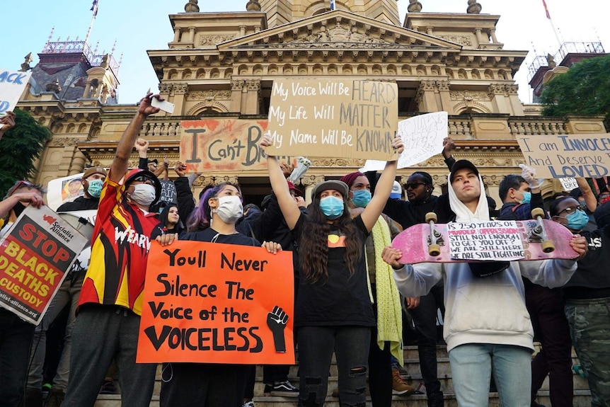 Crowds bearing placards gathered at Sydney Town Hall.