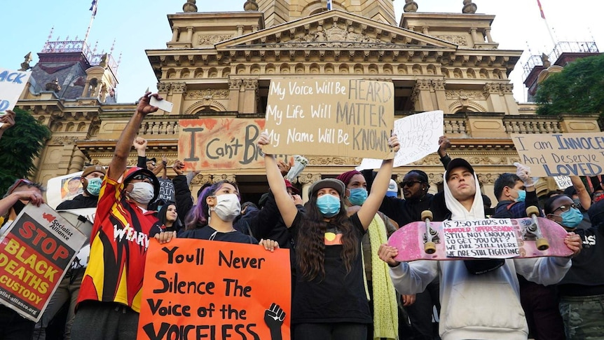 Crowds bearing placards gathered at Sydney Town Hall.