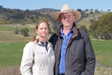 A man and a woman stand in front of a floodplain.